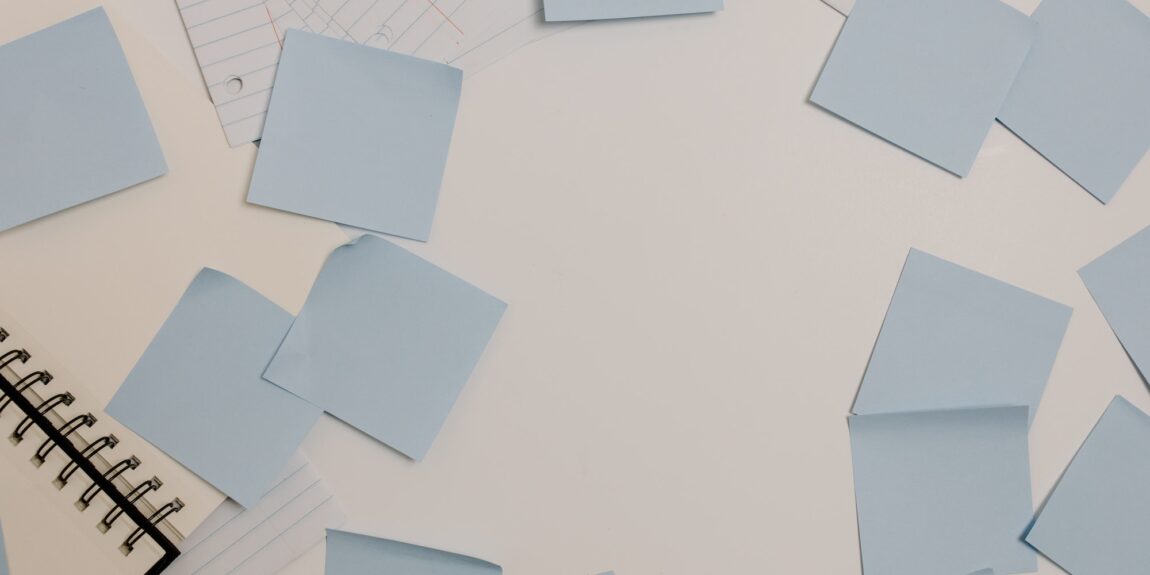 blank sticky notes spread randomly across a white surface - Photo by Tara Winstead: https://www.pexels.com/photo/sticky-notes-scattered-on-white-desk-8386687/