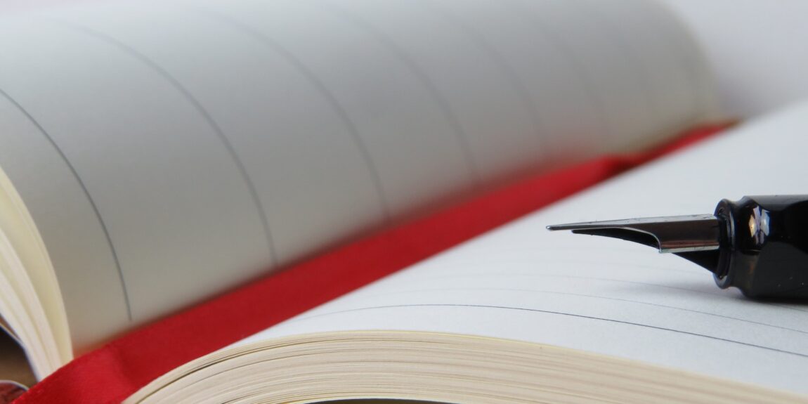 close up of fountain pen nib laying on open journal pages with a red ribbon book mark tucked in the crease - Photo by Pixabay: https://www.pexels.com/photo/blur-close-up-composition-diary-273015/