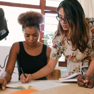 multi-racial group of young people working on a project together - Photo by RF._.studio: https://www.pexels.com/photo/woman-writing-in-paper-3810788/